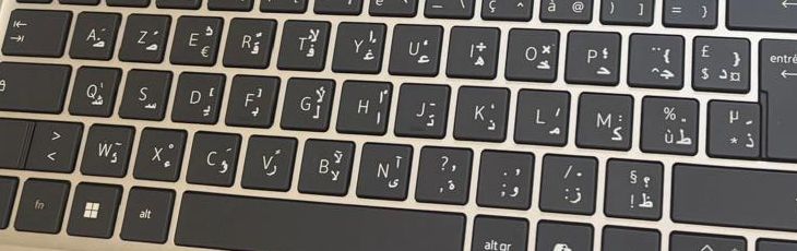 Gros plan de touches de clavier AZERTY avec les lettres arabes ض ص ث ق ajoutées